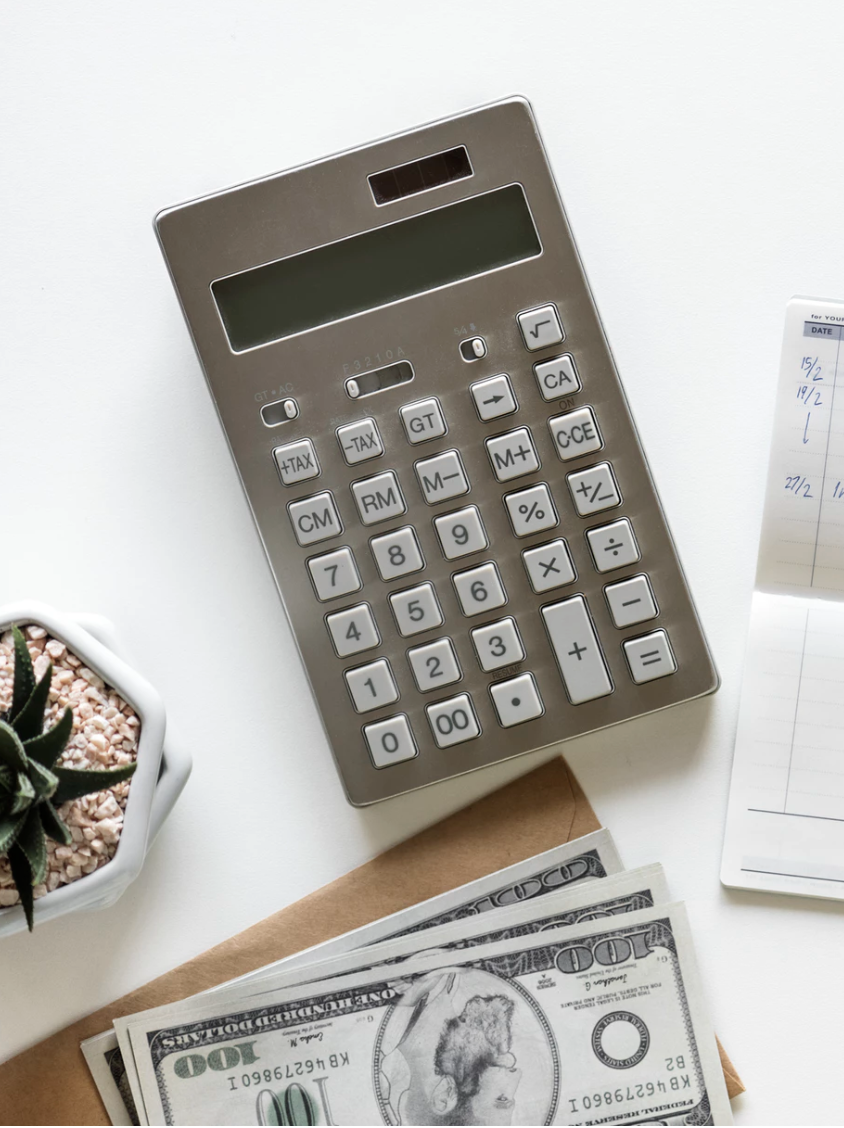 calculator beside hundred dollar bills