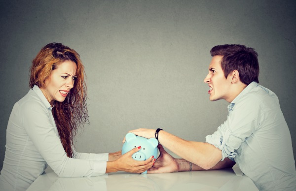 Man and woman fighting over piggy bank